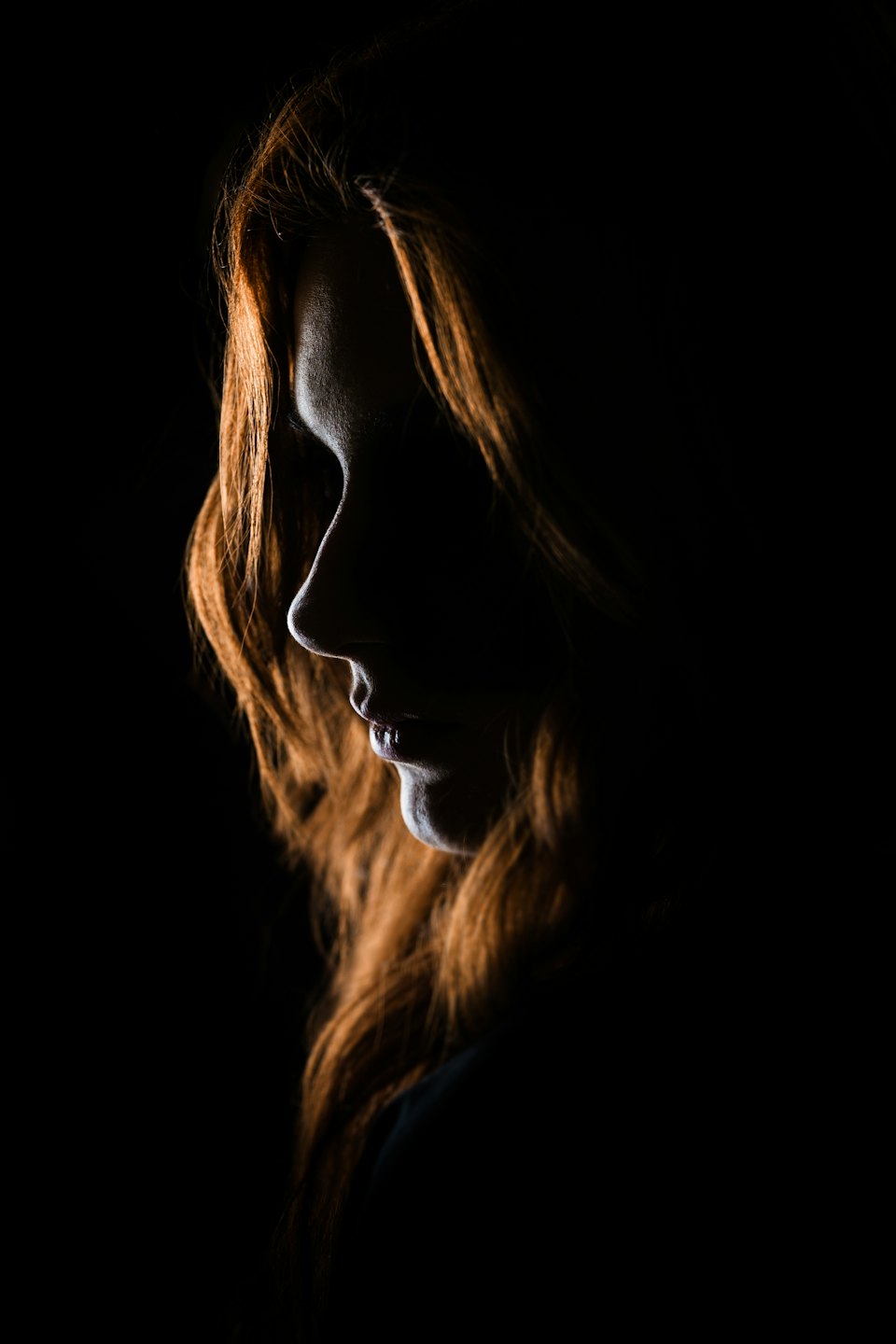 Person with long, reddish-brown hair in profile.
